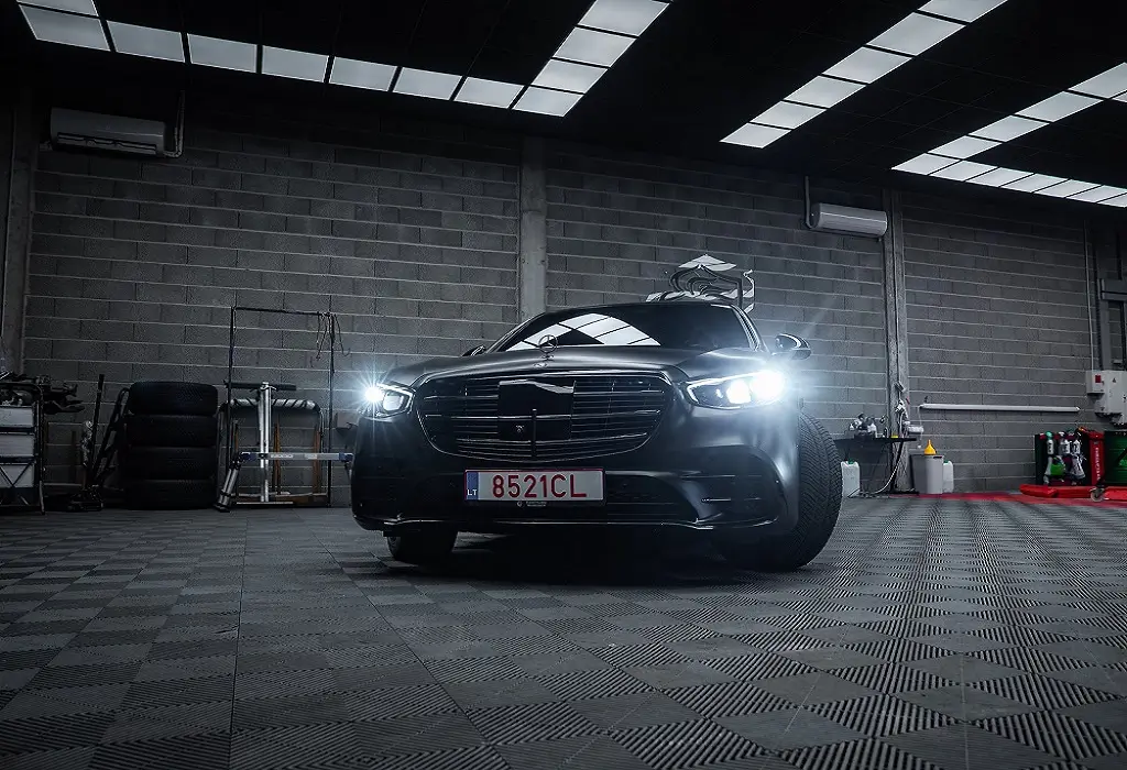 Black car parked on black and grey rubber garage flooring inside a Dubai home garage